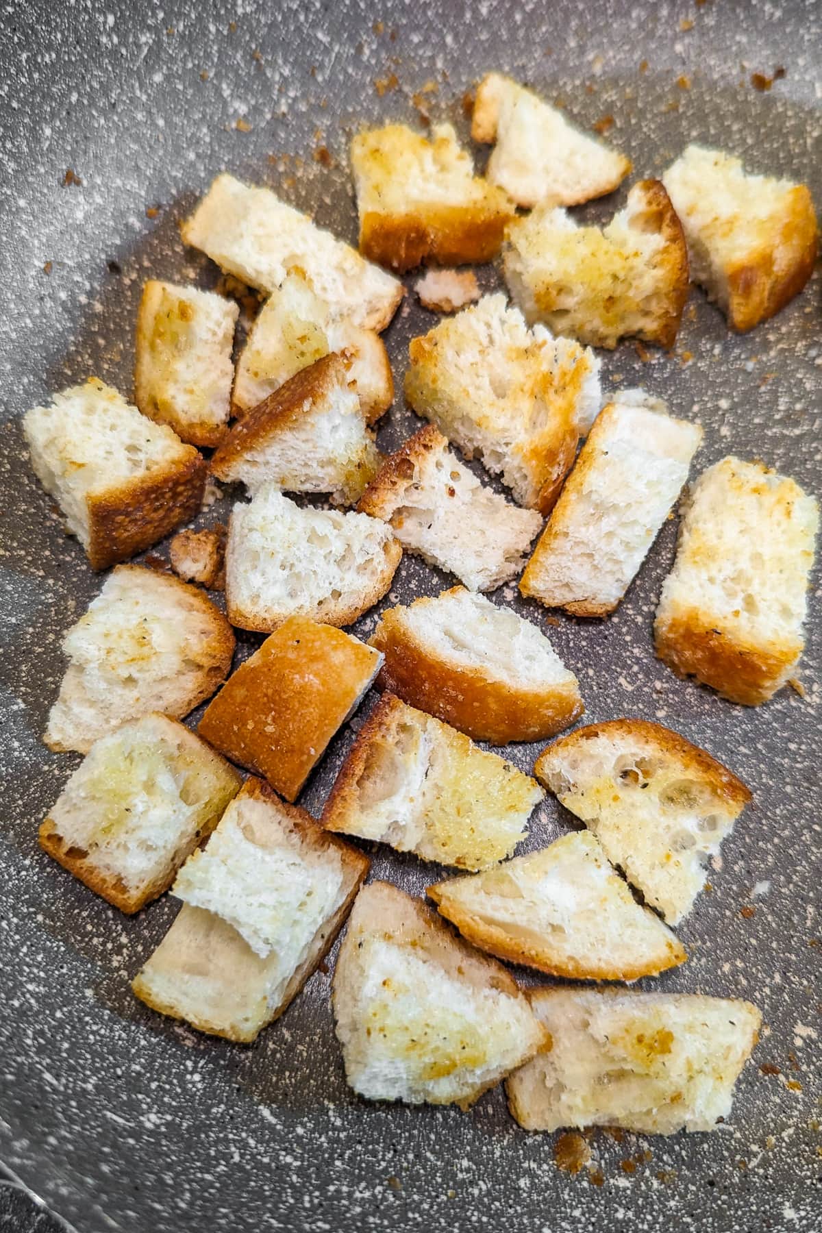 Frying pan with roasted croutons on the stove.