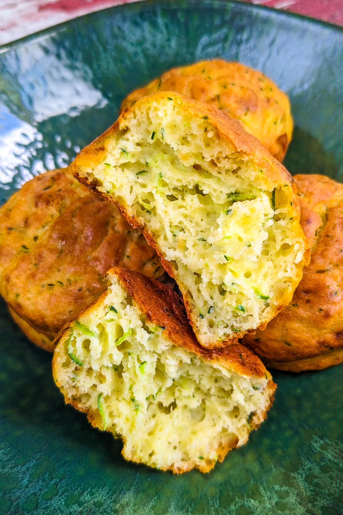 Close look of 4 zucchini muffins served in a green plate.