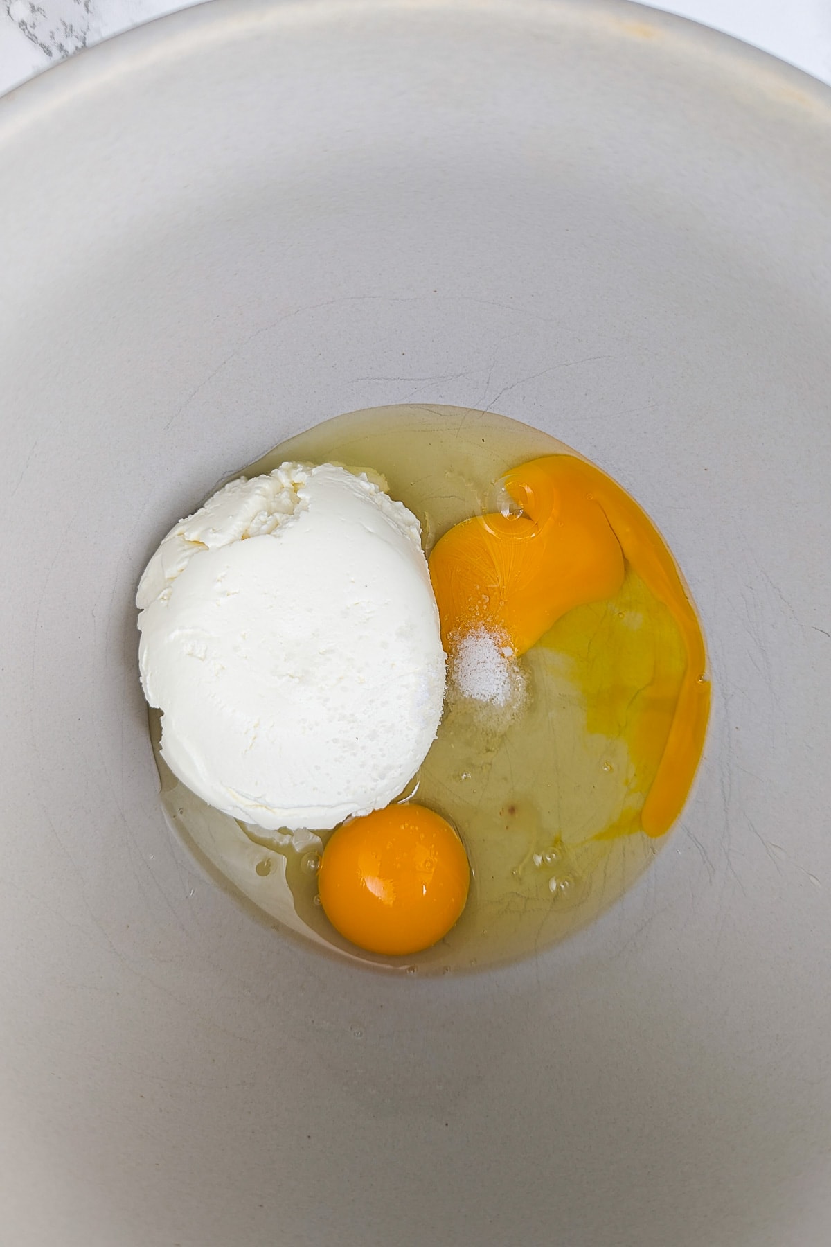 Cream cheese, salt and 2 raw eggs in a deep bowl.