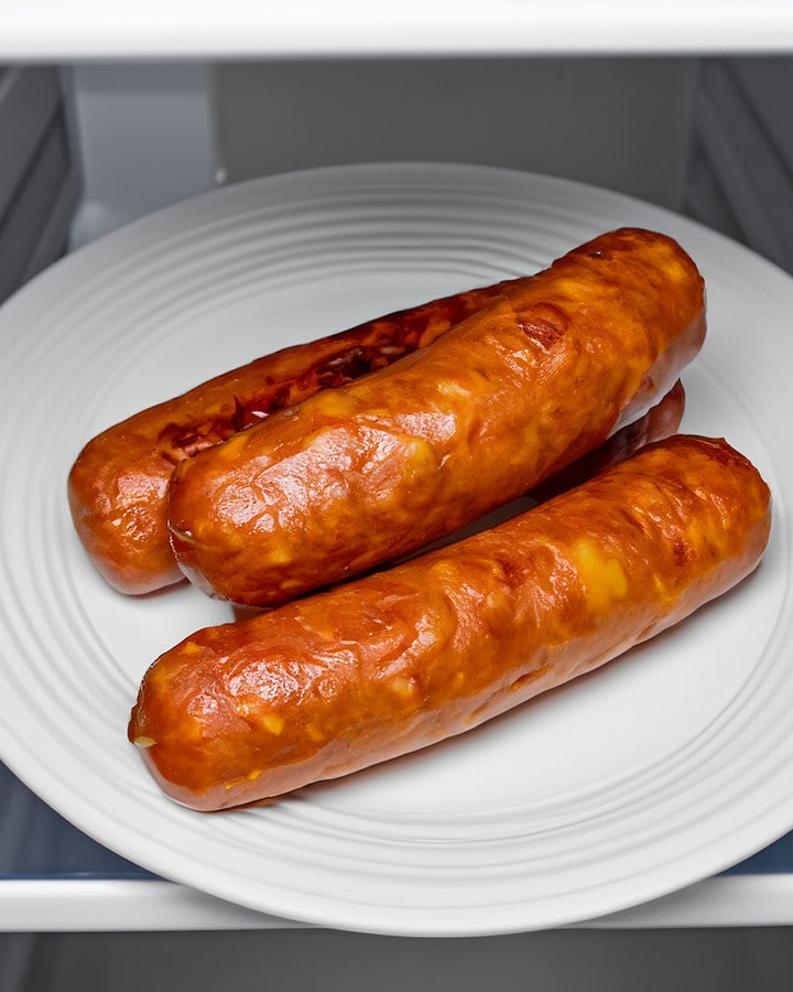 Side look of cooked sausages in the fridge.