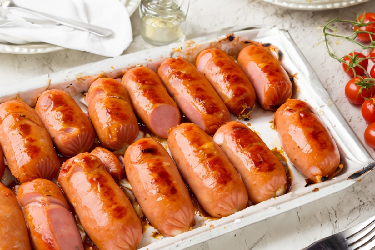 Metal traybake with cooked sausages on the table