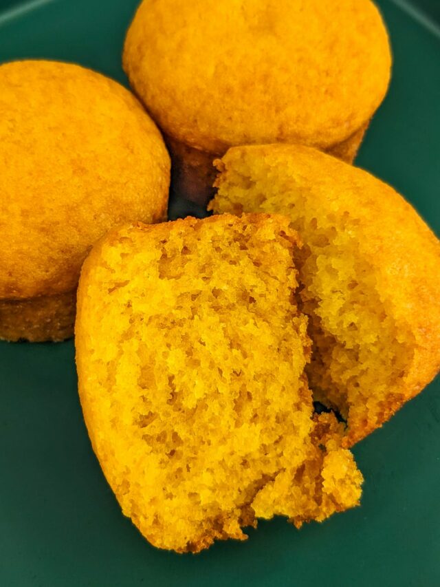 Close look of two halves of pumpkin muffins on a green plate.