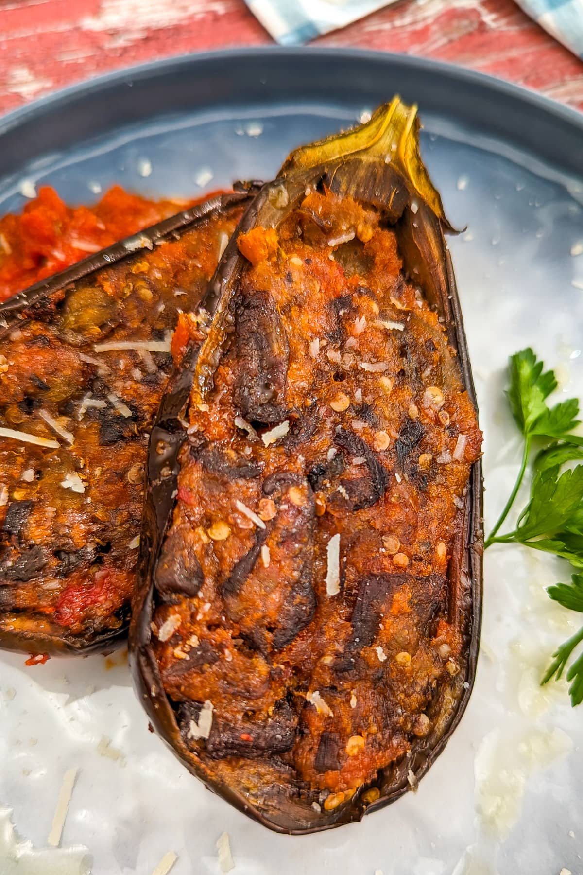 Close look of two eggplant boats stuffed with cheesy mixture.