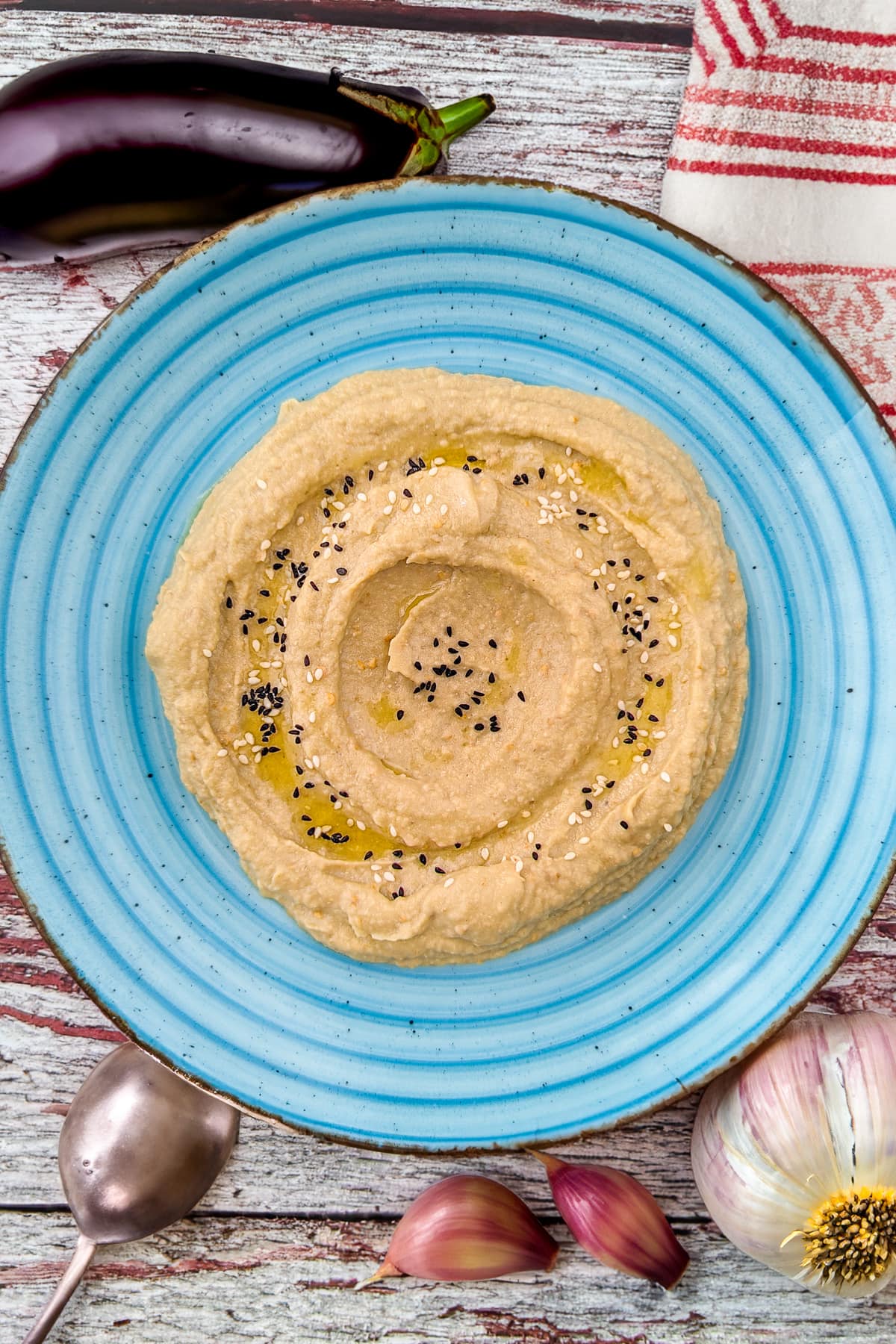 Top view of eggplant dip with tahini in a vintage blue plate.