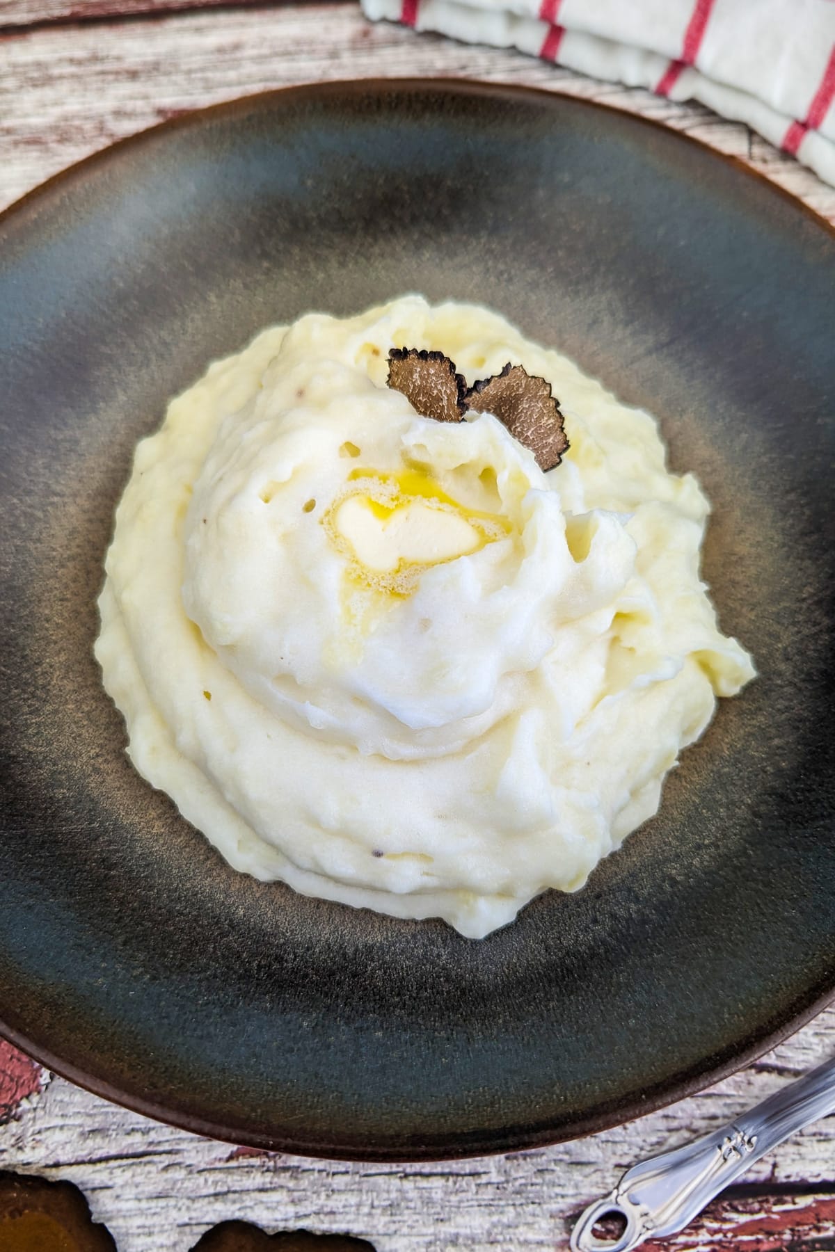 Mashed potatoes with truffles on a vintage plate.