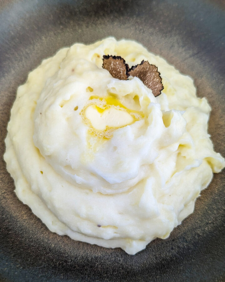 Mashed potatoes with truffles on a vintage plate.