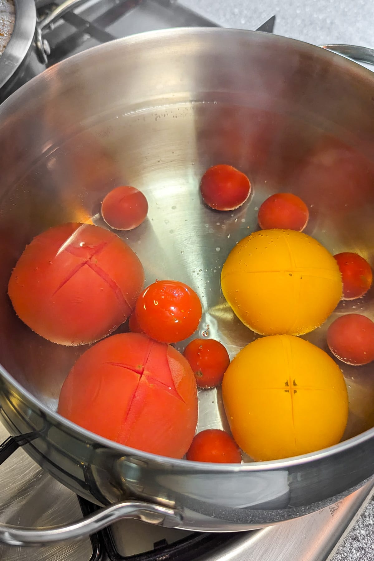 Boiling the tomatoes in a pan with hot water.