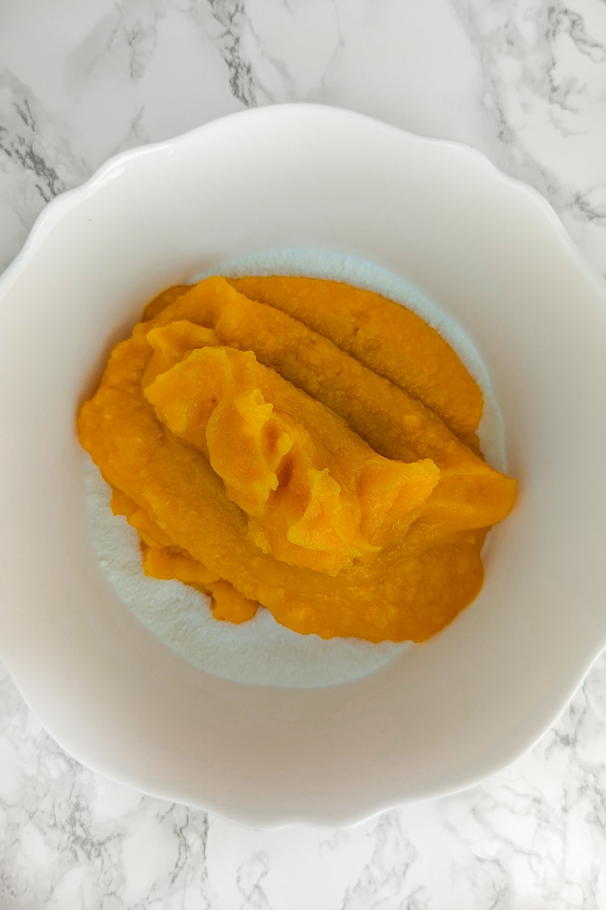 Top view of a plate with sugar, starch and pumpkin puree.