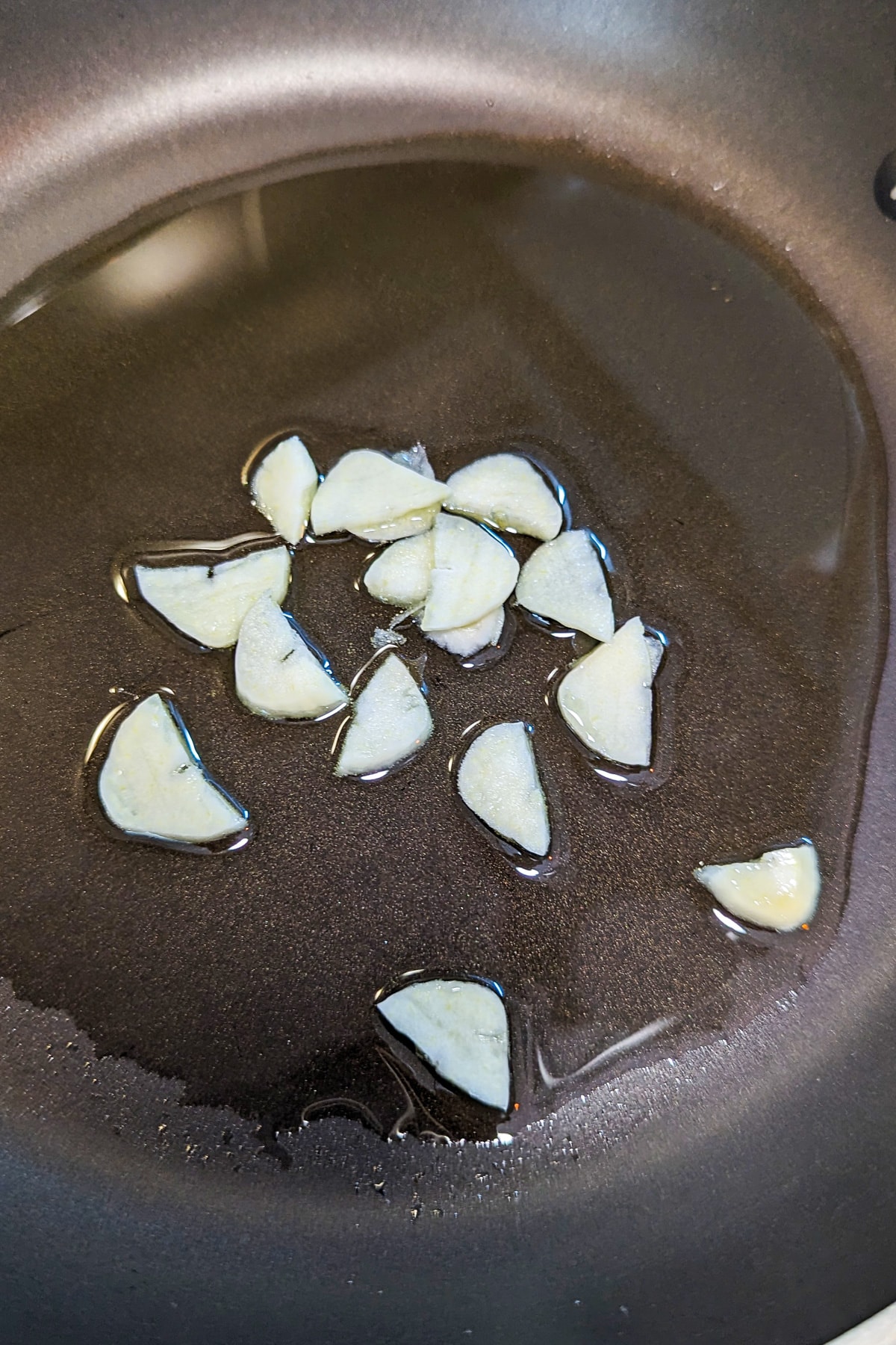 Frying garlic in melted butter on the stove in a pan.