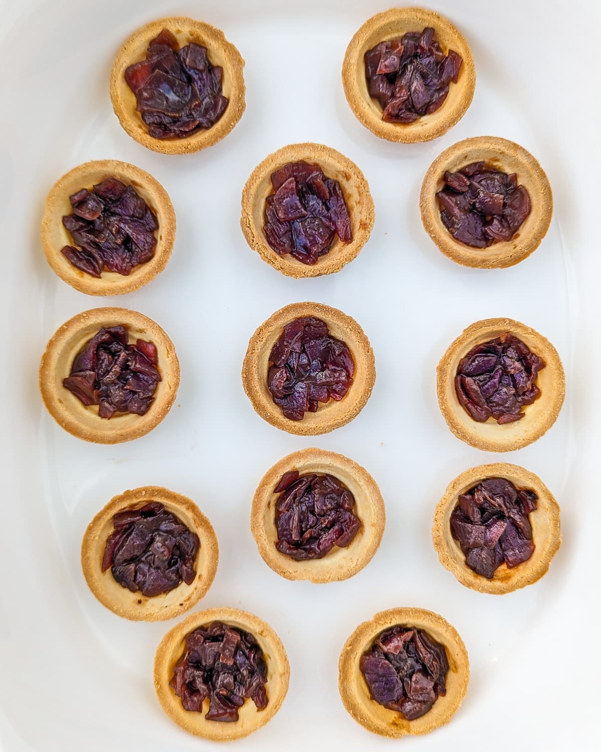 White traybake with tartlets stuffed with caramelized onions.