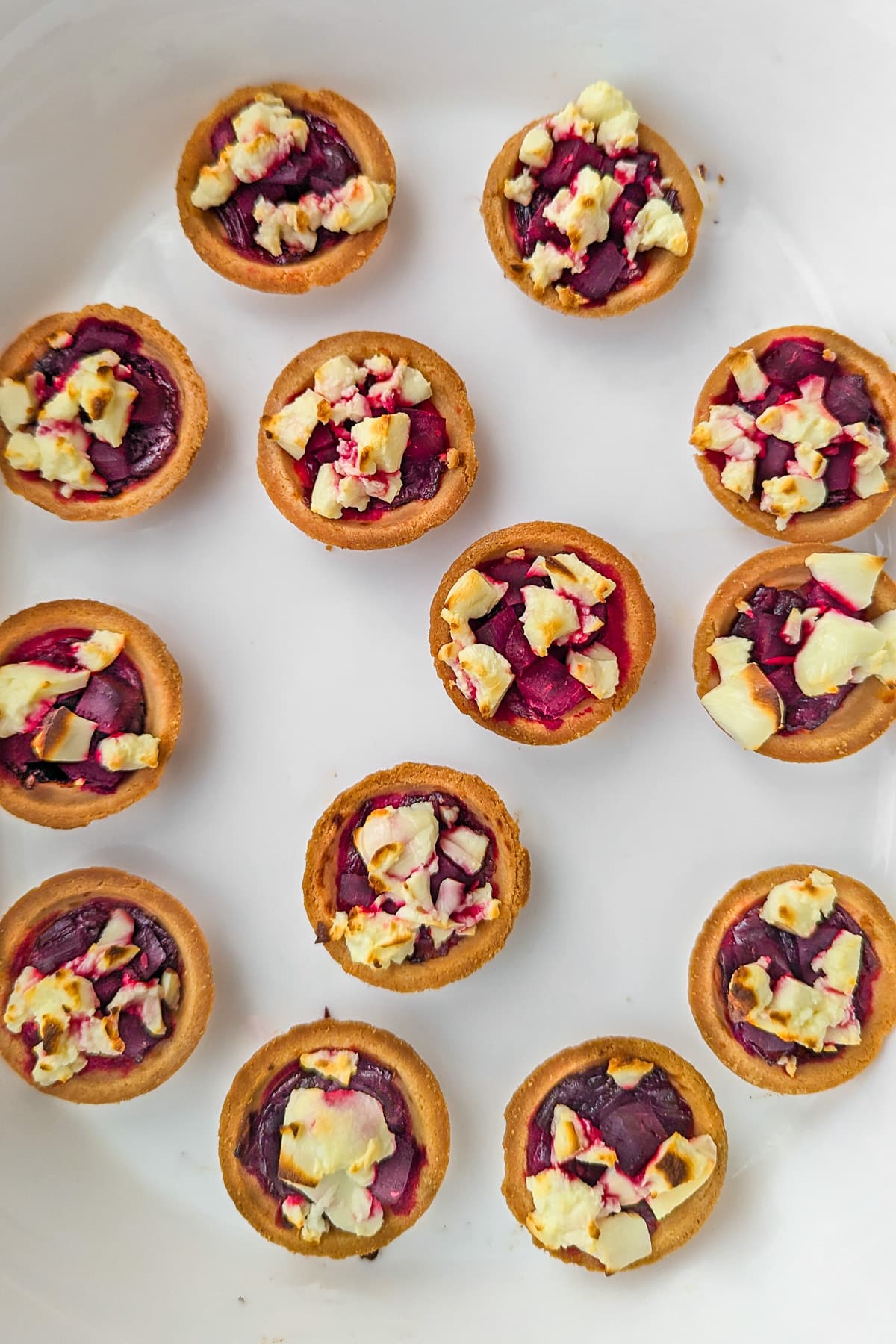 White traybake with beetroot and feta tartlets and caramelized onions.