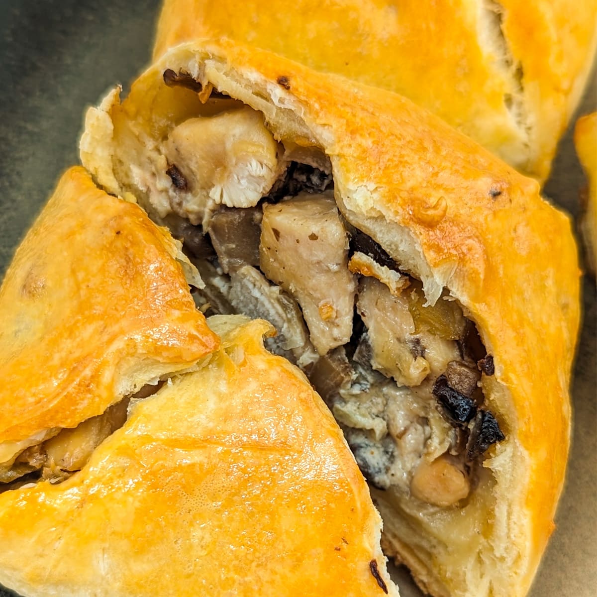 Two halves of chicken parcels in puff pastry made from scratch.