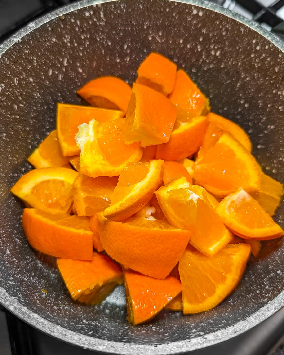Mandarin pieces in a pan on the stove.