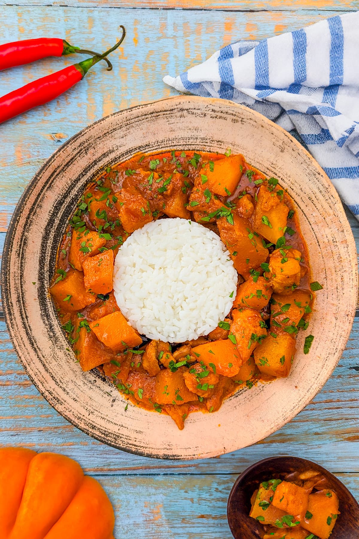 Pumpkin curry with rice and parsley in a vintage plate.