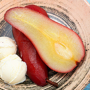 Poached pear halves near ice cream in a vintage plate.