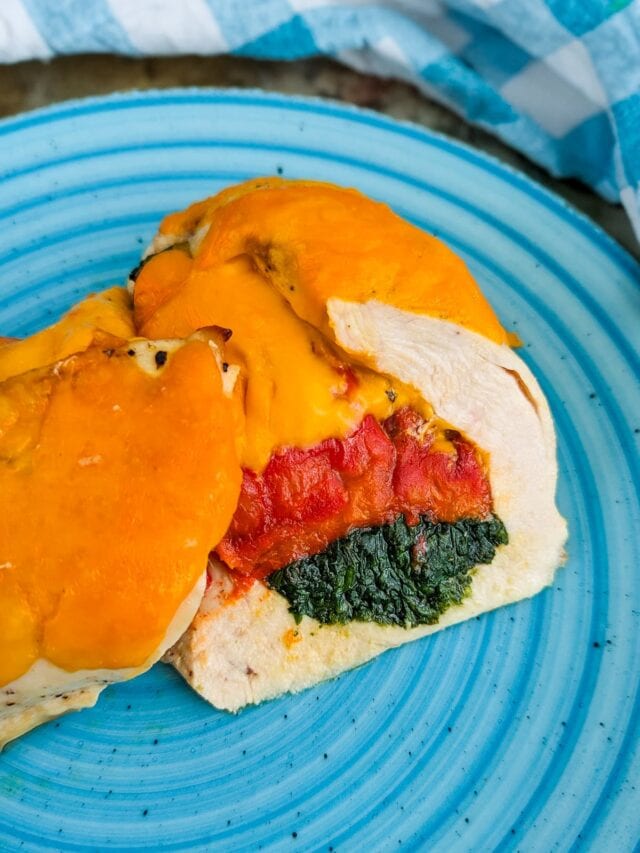 Blue plate with stuffed chicken meat with spinach and bell peppers.