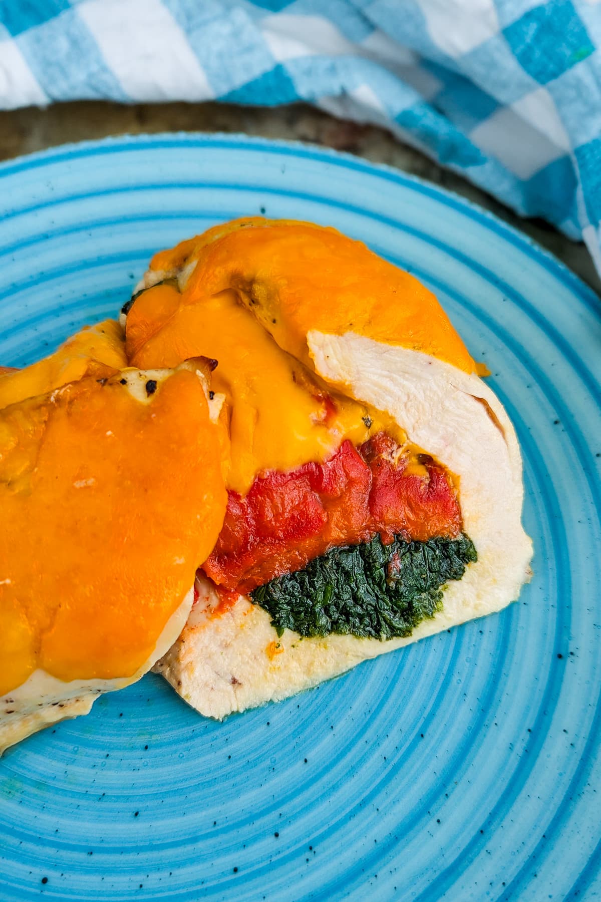 Blue plate with stuffed chicken meat with spinach and bell peppers.