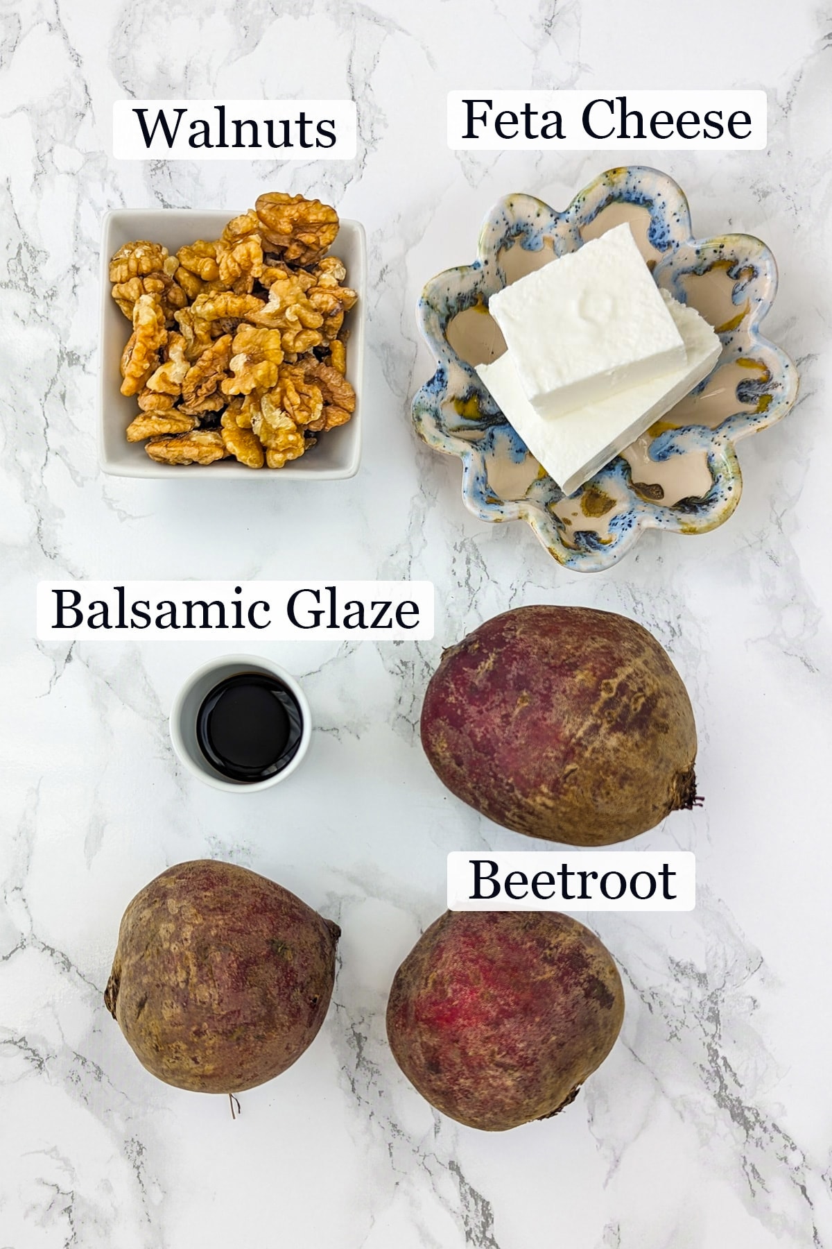 3 Beets, balsamic glaze, brie cheese and walnuts on a white marble surface.