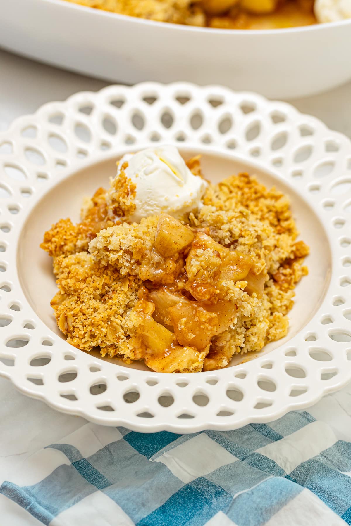 Close look of elegant vintage plate with apple crumble with a scoop of ice cream.
