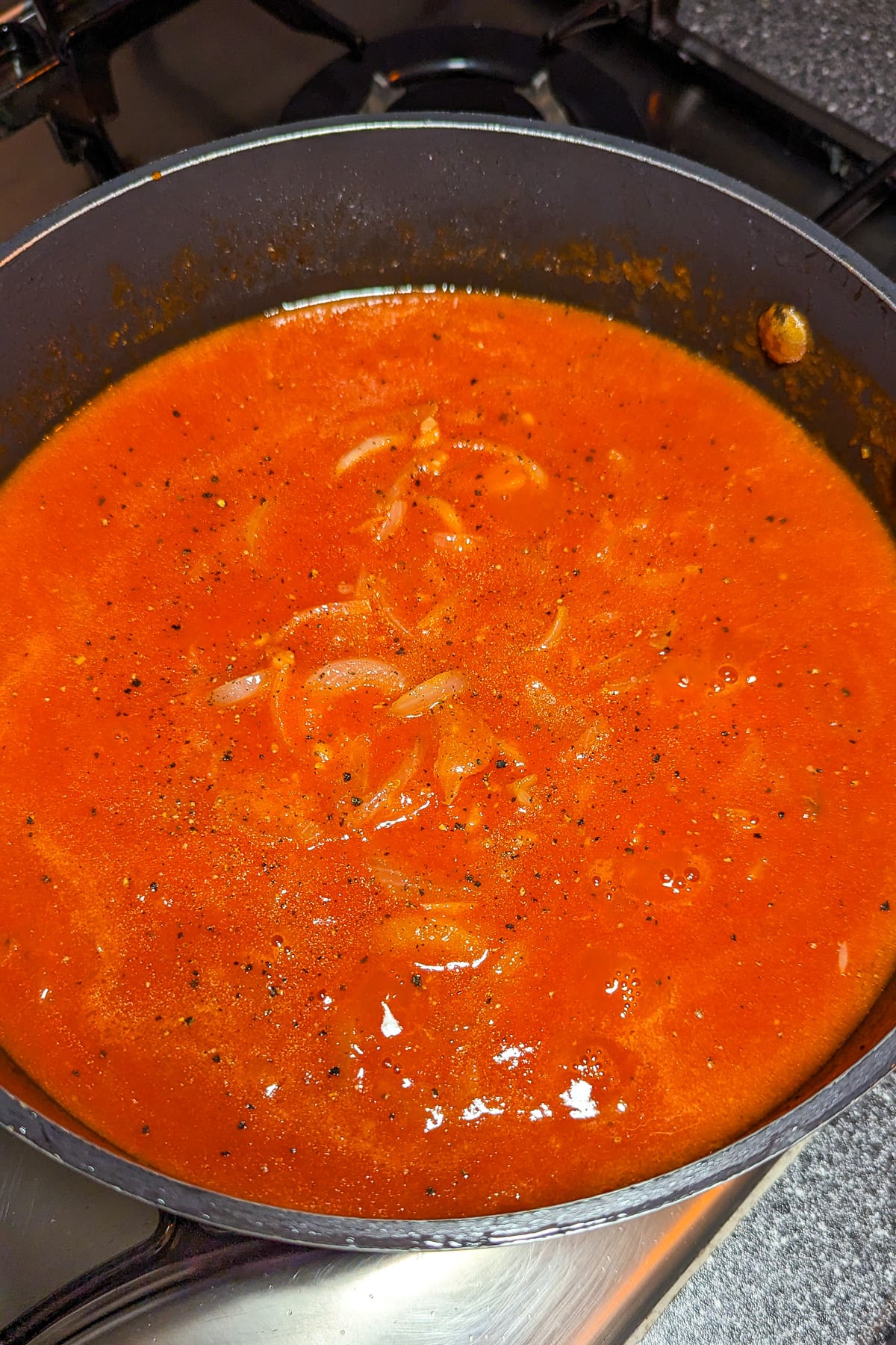 Saucepan with tomato sauce and caramelized onions.