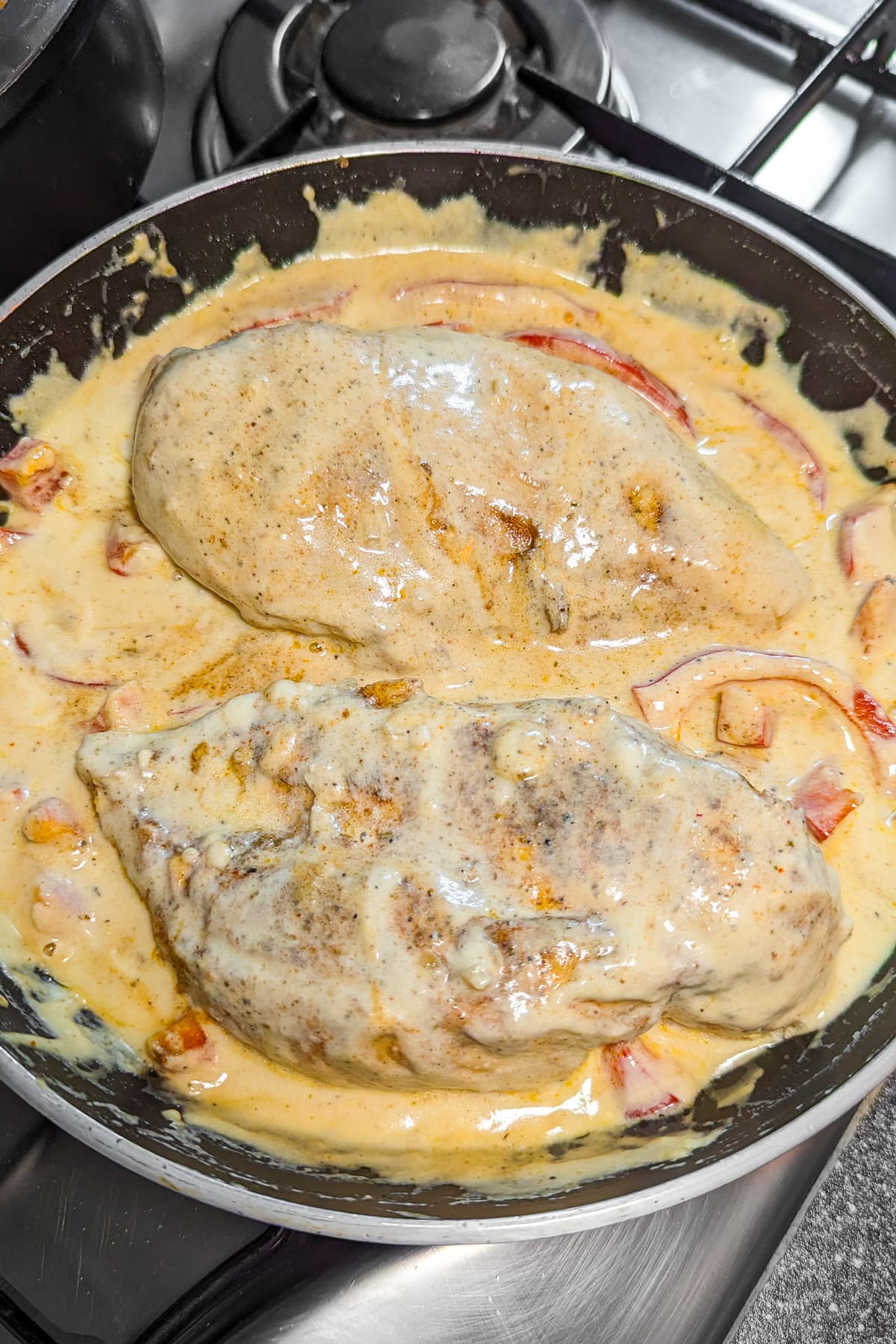 Frying pan with creamy Cajun Chicken on the stove.