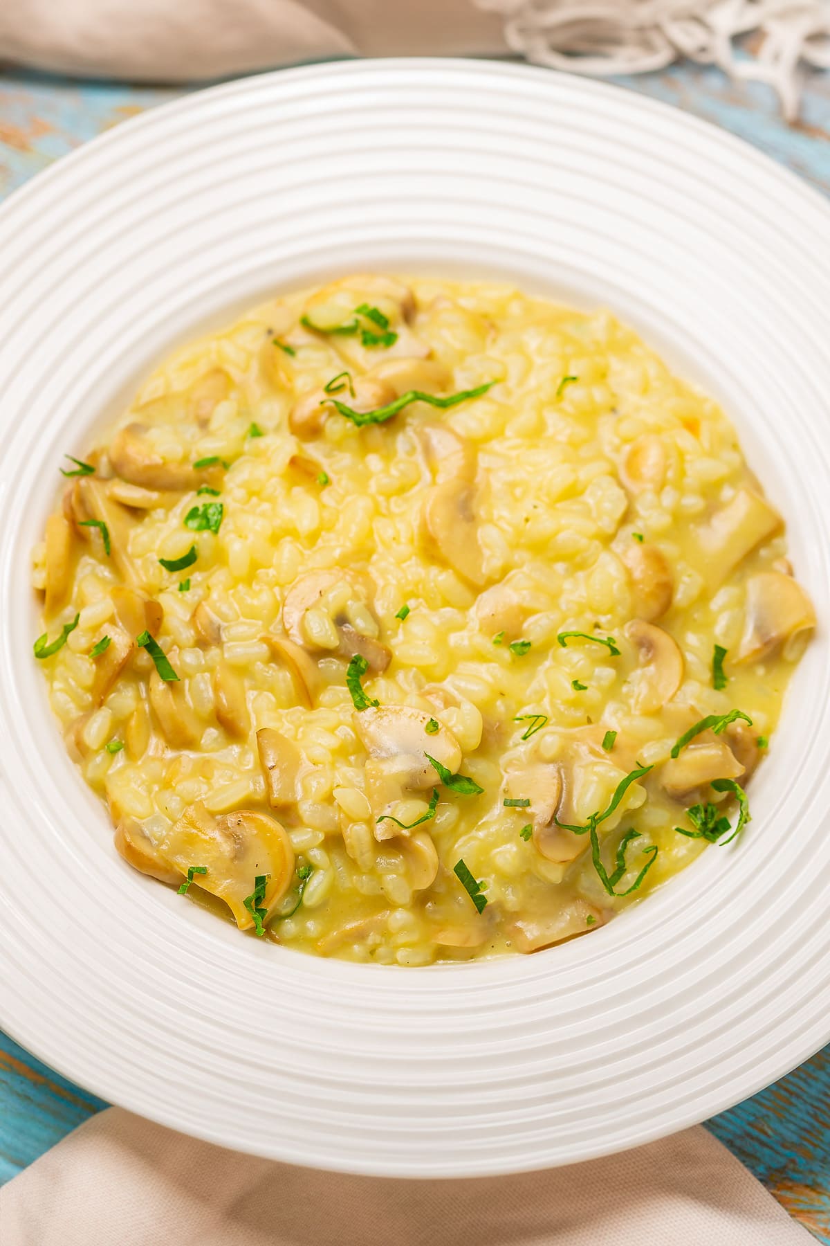 Vintage plate with creamy mushroom risotto decorated with chopped parsley.