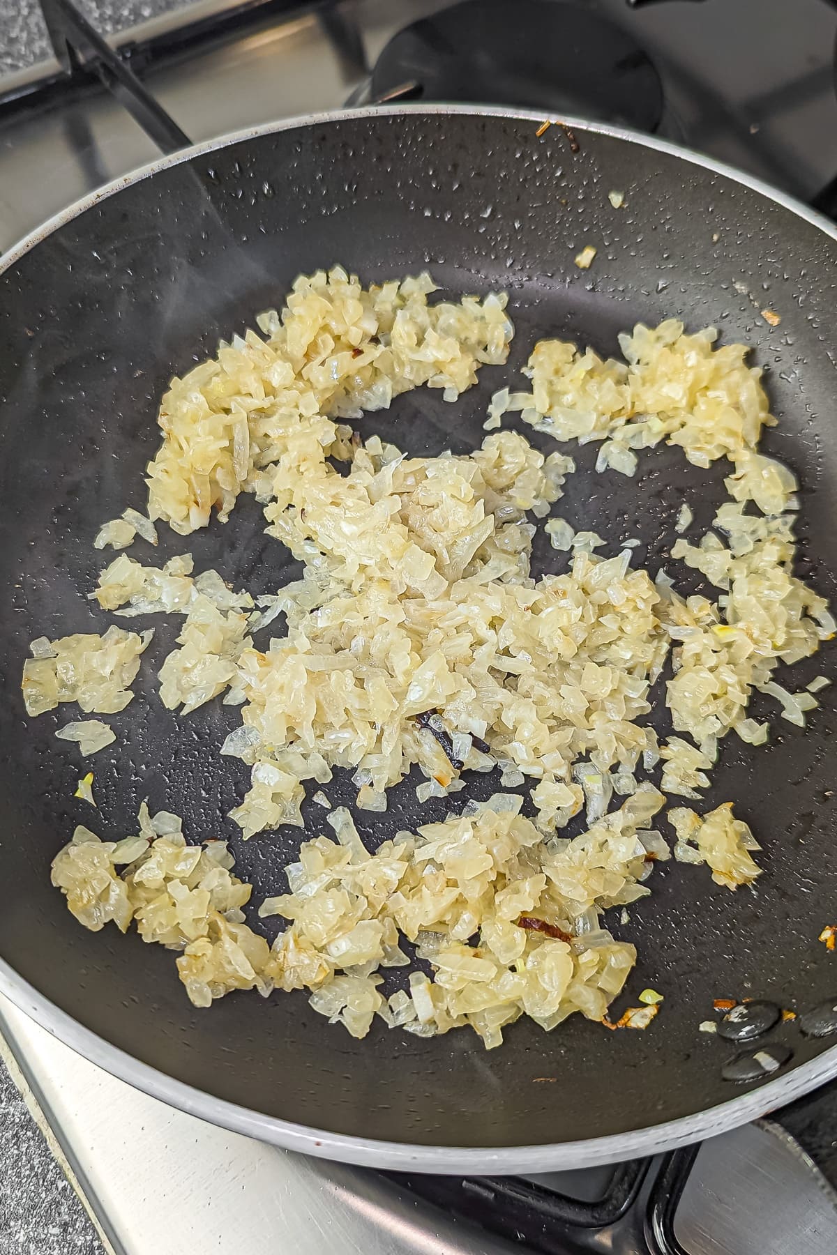 Sautéed golden onions in a pan, ready for more ingredients.