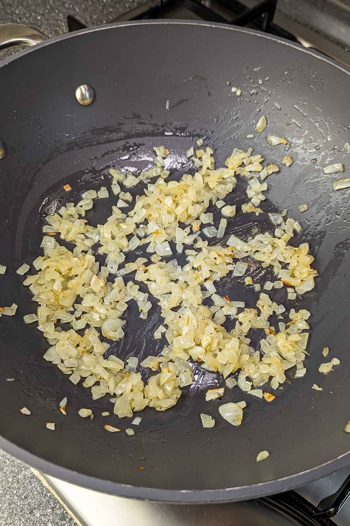 Diced onions sautéed to a translucent state in a large, non-stick frying pan.