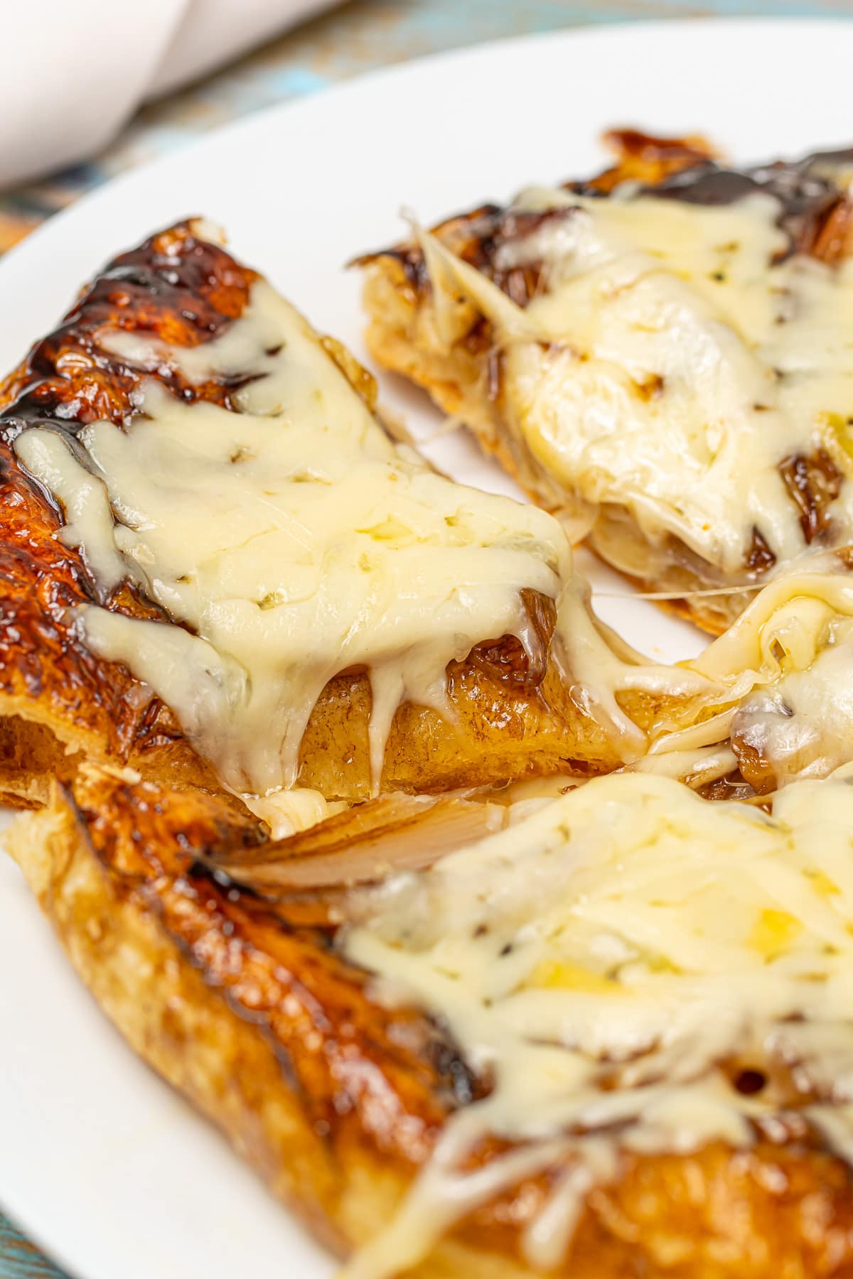 Melting cheese on top of a freshly baked caramelized onion tart.