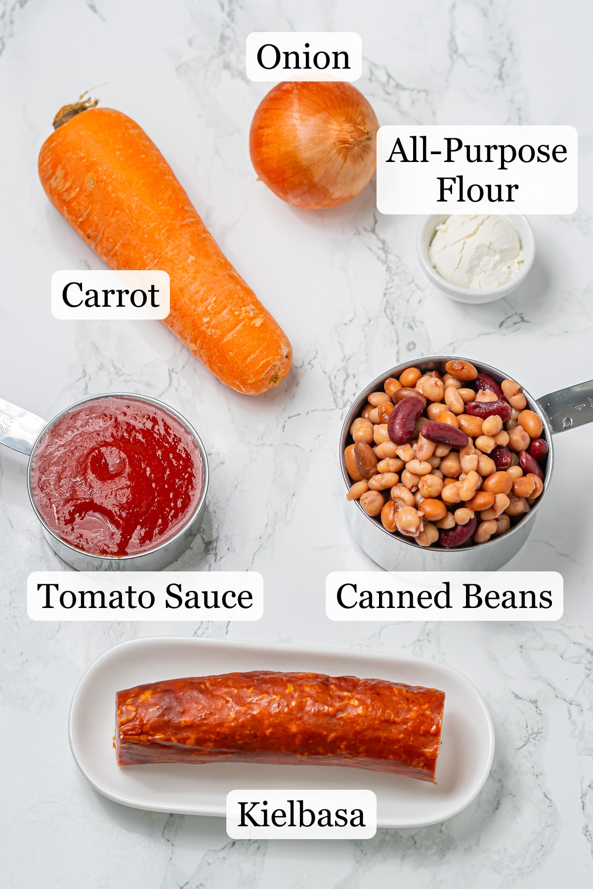 Ingredients for kielbasa bean soup: carrot, onion, tomato sauce, mixed beans, cream cheese, and kielbasa sausage.