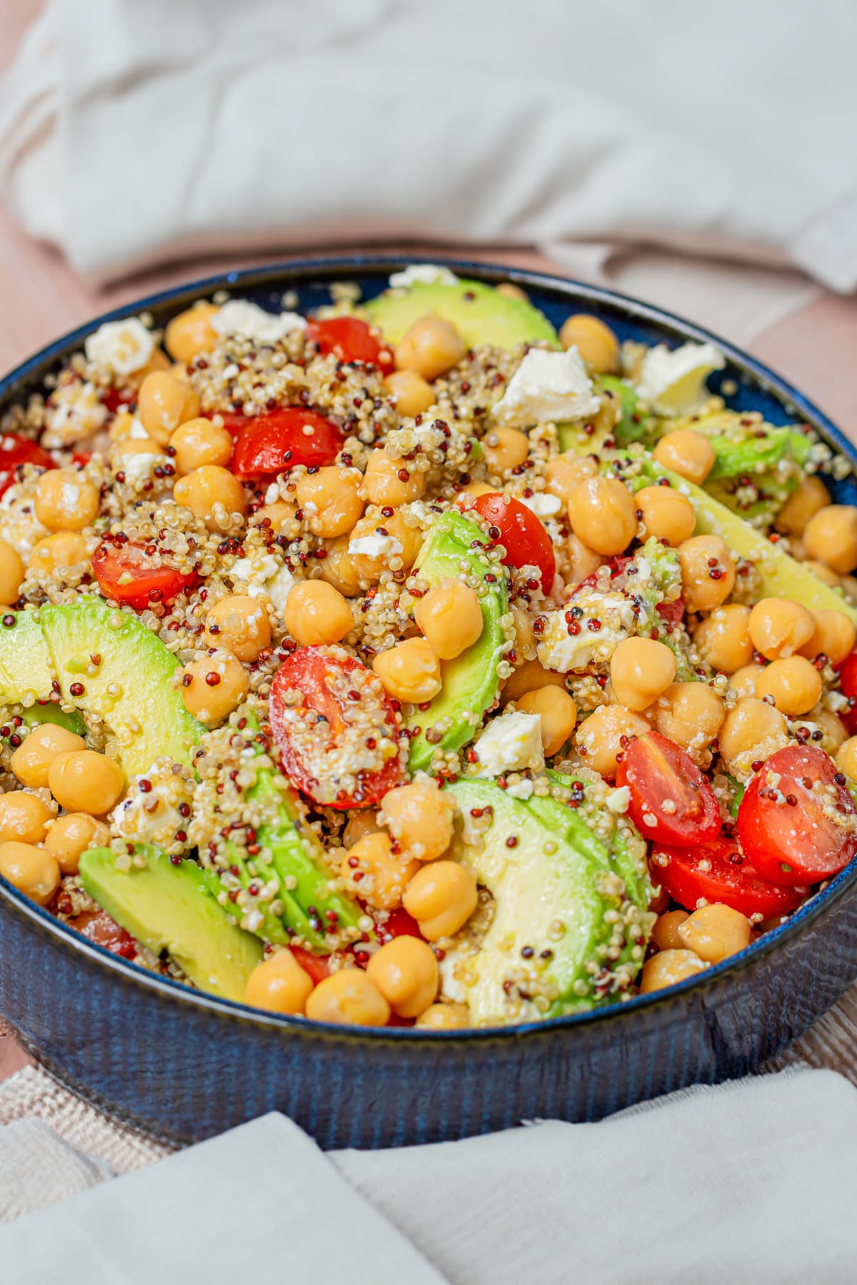 A colorful quinoa chickpea salad with avocado and feta, fully dressed, ready to eat.